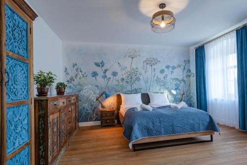 a bedroom with a bed and a blue wall at Dworek Wojanów in Wojanów