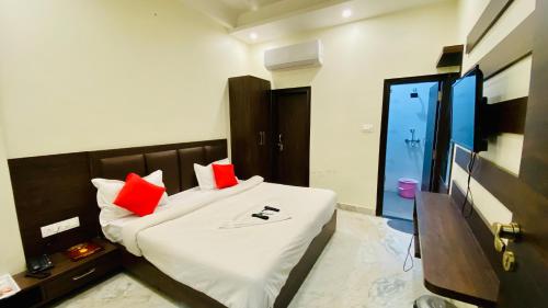 a bedroom with a bed with red pillows on it at Hotel Pulse Inn- Near Jaipur Railway Station in Jaipur