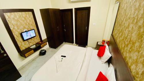 a room with a bed and a television in it at Hotel Pulse Inn- Near Jaipur Railway Station in Jaipur