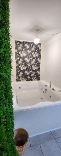 a bathroom with a bath tub next to a green hedge at Apartment Simone in Lecce