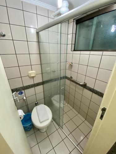 a bathroom with a toilet and a glass shower at Villas diRoma com um dia no Acqua Park, Splash e Slide in Caldas Novas