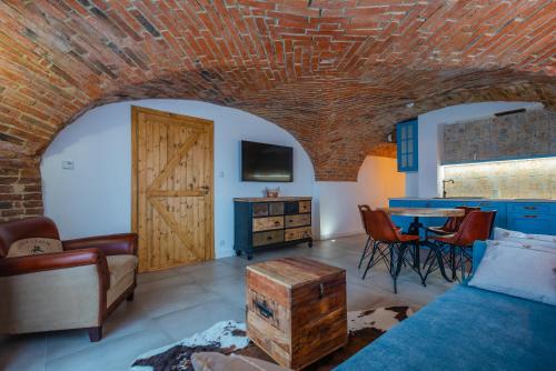 a living room with a brick ceiling and a table with chairs at Dworek Wojanów in Wojanów