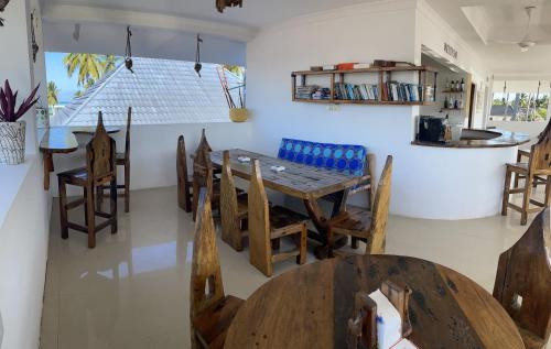 a dining room with a wooden table and chairs at Atlas Hotel Paje in Paje