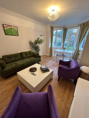 ein Wohnzimmer mit einem Sofa und einem Tisch in der Unterkunft Lovely garden apartment in Wimbledon Town Centre with private parking by Wimbledon Holiday Lets in London