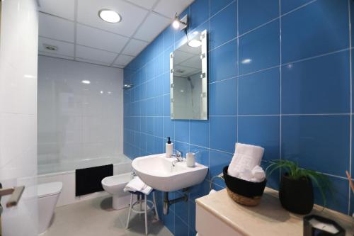 Baño azul con lavabo y aseo en RentalSevilla Apartamento luminoso 2 dormitorios, en Sevilla