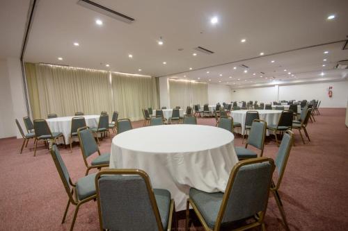 a conference room with a white table and chairs at Oasis Imperial & Fortaleza in Fortaleza
