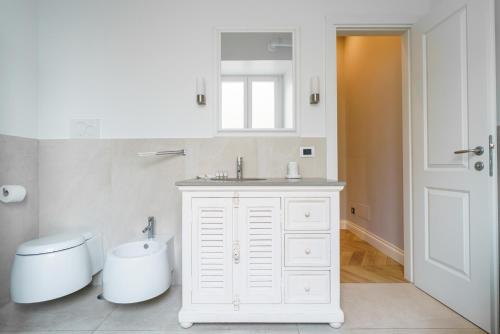 a white bathroom with a sink and a toilet at La Dolce Vita Farini in Rome