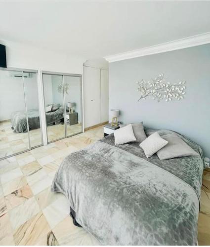 une chambre avec un grand lit et un grand miroir dans l'établissement A deux pas de la Mer, à Marseille