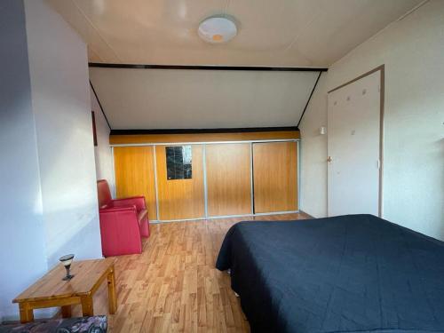 1 dormitorio con 1 cama y suelo de madera en Big Room, en Eindhoven