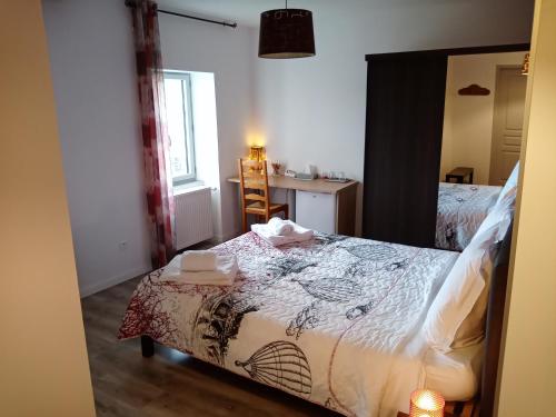 a bedroom with a bed and a table and a mirror at A deux pas du Rheby in Villebois