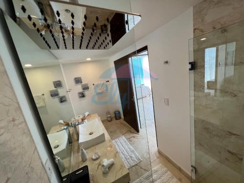 bagno con lavandino, doccia e specchio di Anah Downtown luxury condo a Playa del Carmen