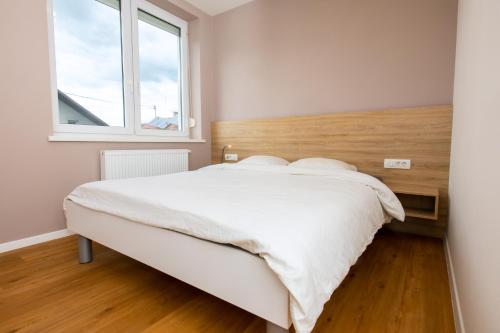 sypialnia z dużym białym łóżkiem i oknem w obiekcie Marko’s apartment 