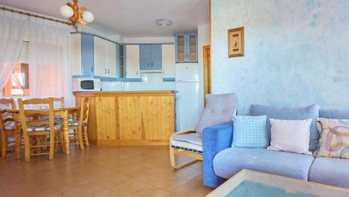 a living room with a blue couch and a kitchen at Apartamento La Pergola Cabo de Gata in El Cabo de Gata