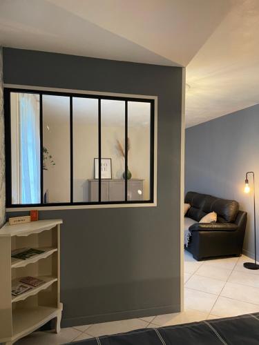 a living room with a couch and a window at Le Havre de Braye in Braye-en-Laonnois