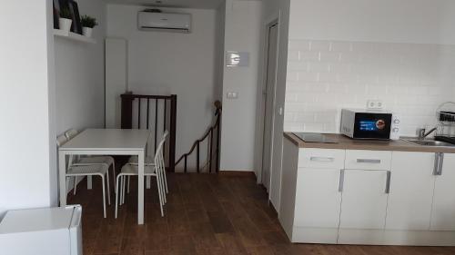 cocina con mesa y mesa pequeña con sillas en apartamento Ciempozuelos II en Ciempozuelos