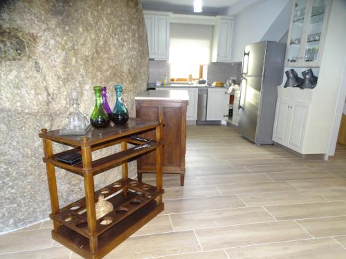 a kitchen with a table with wine bottles on it at Quinta do Cadaval in Cortiçô