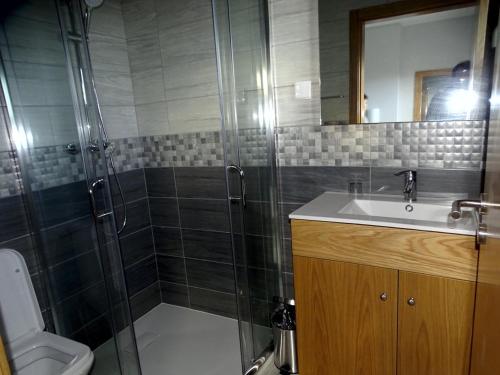 a bathroom with a shower and a sink and a toilet at Quinta do Cadaval 