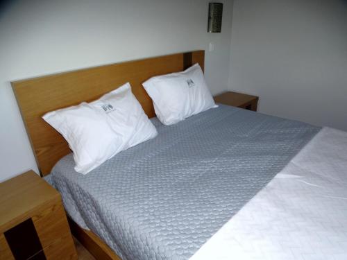 a bed with two white pillows on top of it at Quinta do Cadaval in Cortiçô