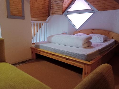 una cama en una habitación con ventana en Moudang 11, en Saint-Lary-Soulan