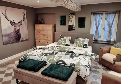 una camera da letto con un letto e un dipinto di cervo sul muro di Maison typique privée - Sart Lez Spa - PINE COTTAGE- charme piscine a Sart