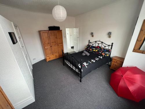 een slaapkamer met een zwart bed en een rode paraplu bij Friends House, Hot Tub, Sleeps 6 in Blackpool