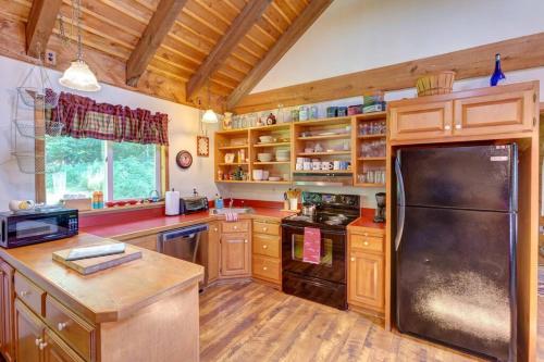 - une cuisine avec des placards en bois et un réfrigérateur noir dans l'établissement Rustic Roost Cabin, à Vega