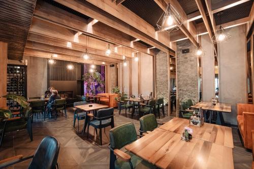 a restaurant with wooden tables and chairs and people at Hotel Forest in Pale