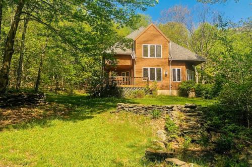 a wooden house with a stone wall in the yard at Catskills Enchanted Forest in Bloomville