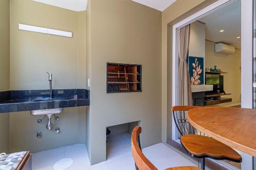 uma cozinha com um lavatório e uma mesa de jantar em Apto Lazuli - Stay House Temporada em Canela