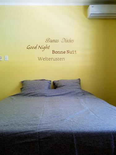 a bedroom with a bed with words on the wall at Casa Bonaventura in Kunuku Abou