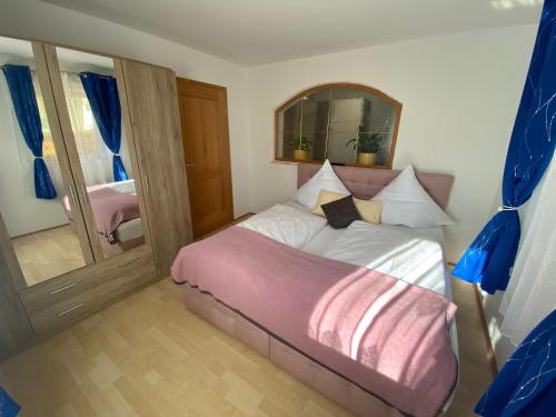 Un dormitorio pequeño con una cama y un espejo. en Pension am Weberhof nur 20 Autominuten von München, en Ebersberg