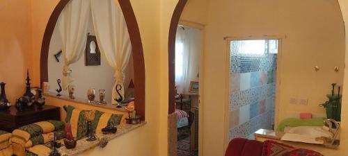 a living room with a mirror and a bathroom at Riad lala zakia in Moulay Idriss Zerhoun
