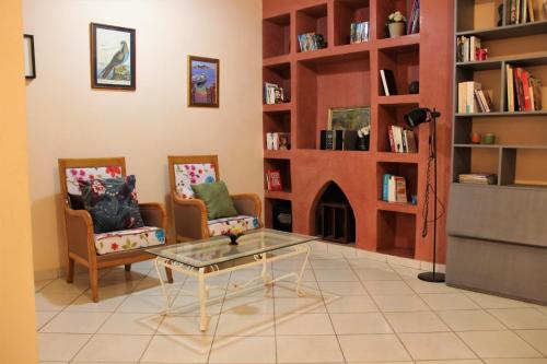 uma sala de estar com 2 cadeiras, uma mesa e uma lareira em luxury villa em Agadir