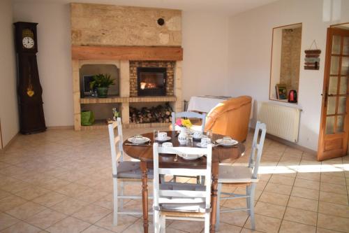 une salle à manger avec une table et des chaises et une cheminée dans l'établissement Chambre d'hôtes Auriac du Périgord, à Auriac-du-Périgord