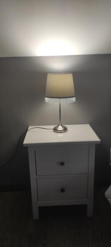 a lamp sitting on a night stand in a room at Kaszuby Punkt Klonowo Przywidz sauna klima basen in Przywidz