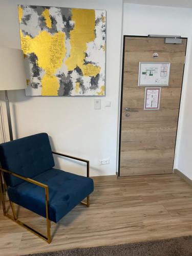 a room with a blue chair and a door at A&C Hotel in Backnang