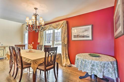 a dining room with red walls and a table and chairs at Beautiful Lakefront Retreat with Deck and Views! in Newton