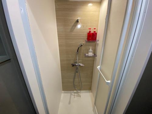 a shower with a hose in a bathroom at Hotel Jungle fun fun in Osaka