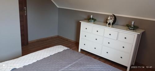 a bedroom with a white dresser with two candles on it at Kaszuby Punkt Klonowo Przywidz sauna klima basen in Przywidz