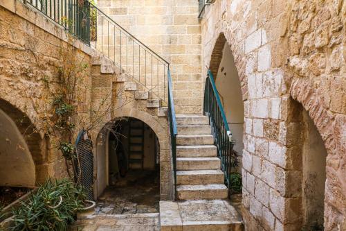The Maimon House- Old City, Jerusalem في القدس: مجموعة من السلالم في زقاق بين مبنيين