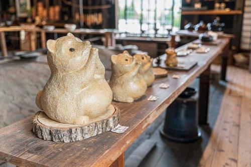 three figurines of cats sitting on a wooden table at 朝ドラのロケ地 信楽焼きの窯元に泊まれます 無料駐車場有 4人まで宿泊可能 in Nagano