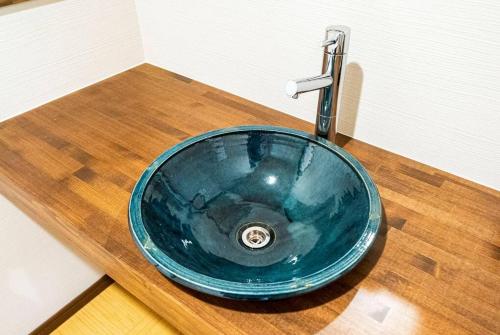 a blue sink with a faucet on a wooden counter at 朝ドラのロケ地 信楽焼きの窯元に泊まれます 無料駐車場有 4人まで宿泊可能 in Nagano