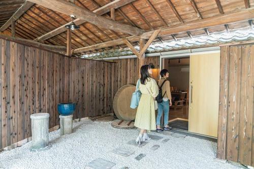 a woman in a yellow dress standing in a room at 朝ドラのロケ地 信楽焼きの窯元に泊まれます 無料駐車場有 4人まで宿泊可能 in Nagano