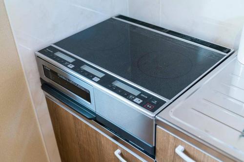 a stove top oven sitting on top of a refrigerator at 朝ドラのロケ地 信楽焼きの窯元に泊まれます 無料駐車場有 4人まで宿泊可能 in Nagano