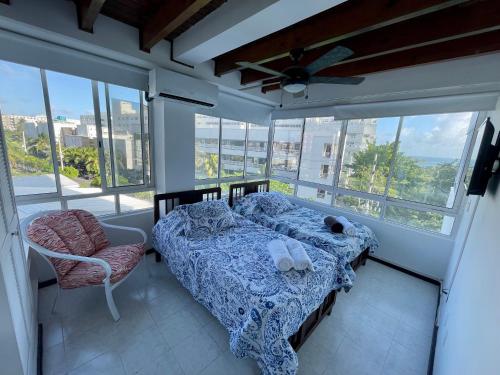 sypialnia z łóżkiem oraz balkon z oknami w obiekcie Exclusivo apartamento Duplex Bahia fragata w mieście San Andrés