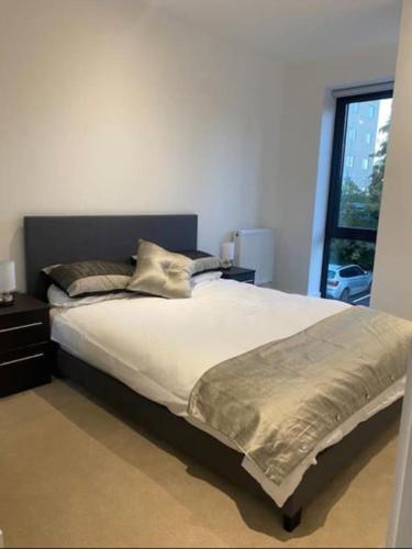 a large bed in a bedroom with a window at Brand new luxury apartment with free parking and gym in Olton