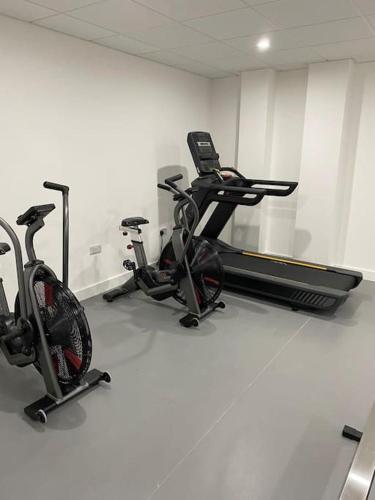 a gym with two exercise bikes and a mirror at Brand new luxury apartment with free parking and gym in Olton