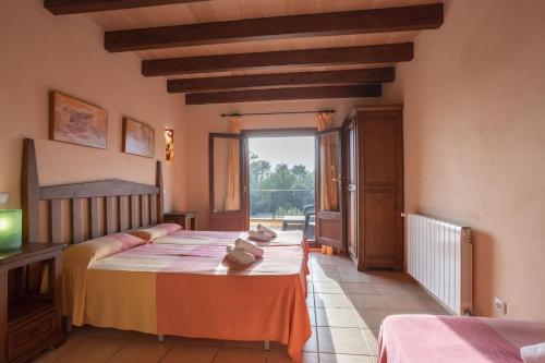 a bedroom with two beds and a large window at Finca Sa Mina Family in El Port de la Selva