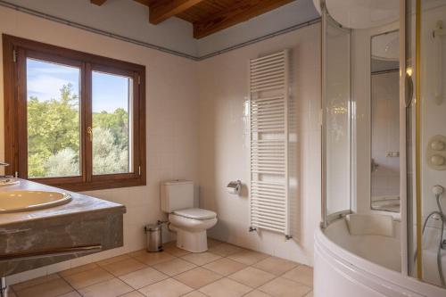 a bathroom with a tub and a toilet and a sink at Finca Sa Mina Family in El Port de la Selva