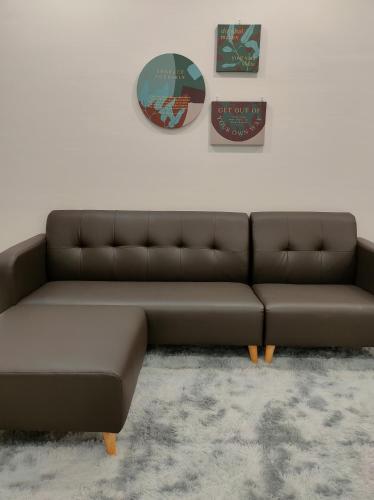 a brown couch sitting in a living room at New 2BR Georgetown Warm and Lovely Homestay 10pax-无敌美景两房民宿 Beacon Executive Suite in George Town